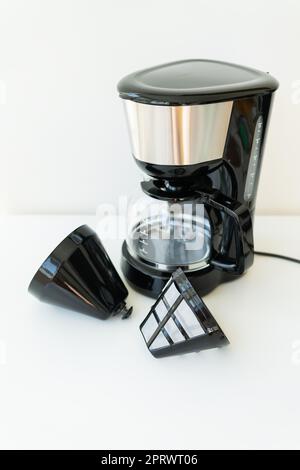 Cafetière goutte-à-goutte automatique isolée sur une table blanche. Cafetière goutte-à-goutte moderne noire. Cuisine électrique petits appareils ménagers. Appareils. Banque D'Images