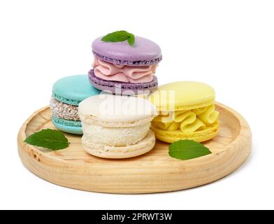 Macarons multicolores cuits sur une assiette en bois Banque D'Images