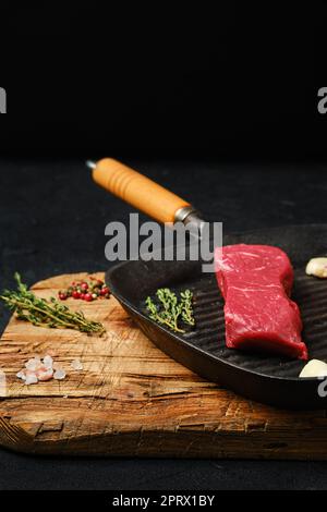 Steak de bœuf désossé cru à trois pointes sur une poêle Banque D'Images