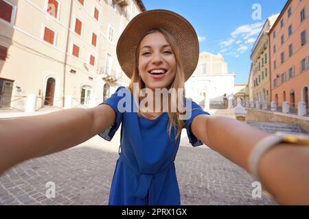 Fille souriante en robe bleue et chapeau prend la photo de selfie à Ancona, Marche, Italie Banque D'Images