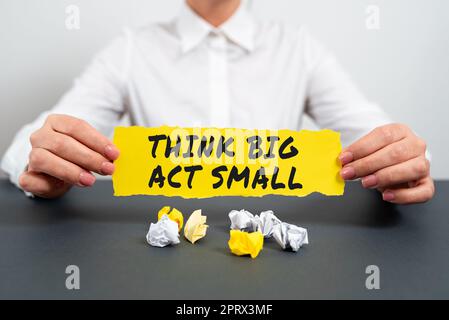 Affiche textuelle montrant Think Big Act Small. Mot écrit sur les grands objectifs ambitieux prendre peu de pas un à la fois Banque D'Images