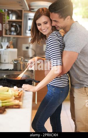 Cuisiner ensemble leur repas préféré. un jeune couple affectueux cuisant un repas ensemble dans sa cuisine Banque D'Images