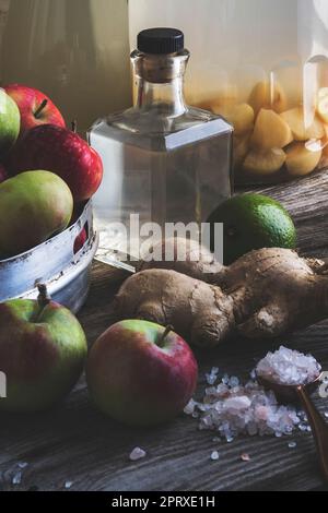 Bouteille de vinaigre de cidre de pomme sur fond rustique avec pommes biologiques, gingembre et sel de cristal Banque D'Images