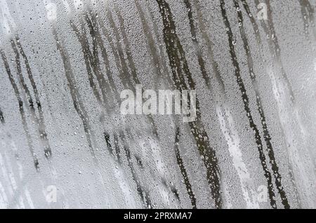 La texture d'un verre embué avec beaucoup de gouttes et de condensation coule. Image d'arrière-plan Banque D'Images