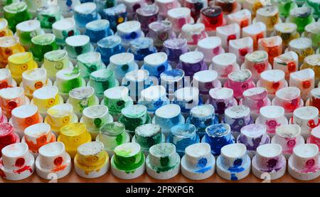 Un motif dans un bon nombre de buses d'un pulvérisateur de peinture pour dessiner des graffitis, des traînées en différentes couleurs. Les capuchons en plastique sont disposés en plusieurs rangées pour Banque D'Images
