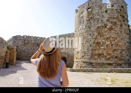 Vacances à Rhodes, Grèce. Vue arrière d'une fille voyageur visitant les fortifications de Rhodes. Jeune femme touriste en visite dans le sud de l'Europe. Banque D'Images