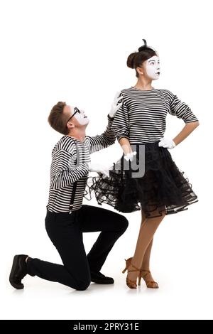 Smiling mimes en chemises à rayures. femme offensé et demande de pardon isolé sur fond blanc Banque D'Images