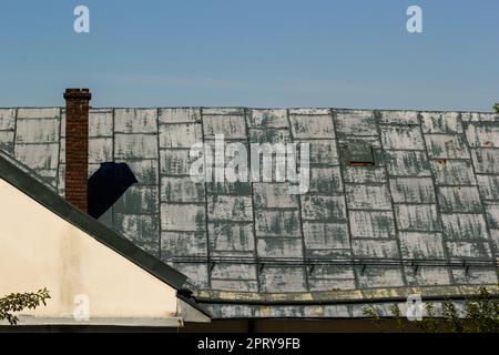 Toit métallique d'une maison individuelle et cheminée contre le ciel, tuiles de toit en métal, gouttières. Banque D'Images