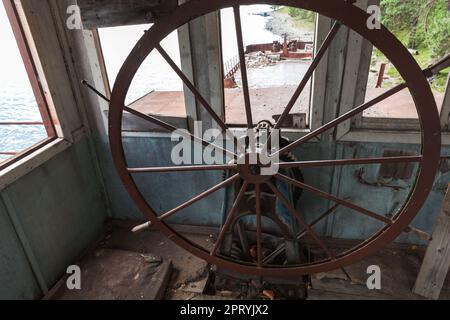 Passage de roue d'une barge abandonnée. Vider le pont capitaine avec volant rouillé Banque D'Images