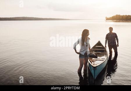 Prenez le lac et votre stress s'évaporera. un jeune couple venant d'une balade en canoë sur le lac. Banque D'Images