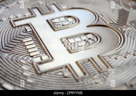 Gros plan d'un bitcoin physique avec une surface de relief brillante en chocolat. Image abstraite de la monnaie crypto sous une forme comestible Banque D'Images