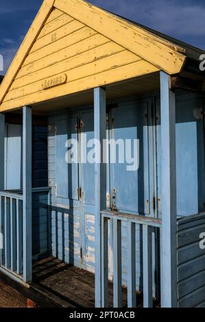 Cabane de plage, cabine ou boîte de bain aux couleurs bleu et jaune, sur la Promenade de Southwold, une station balnéaire surplombant la mer du Nord à Suffolk, Angleterre, Royaume-Uni. Banque D'Images