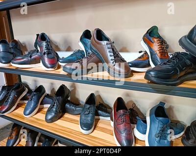 De nombreuses chaussures en cuir fabriquées à la main pour hommes sont placées sur les étagères de la boutique de chaussures. Banque D'Images