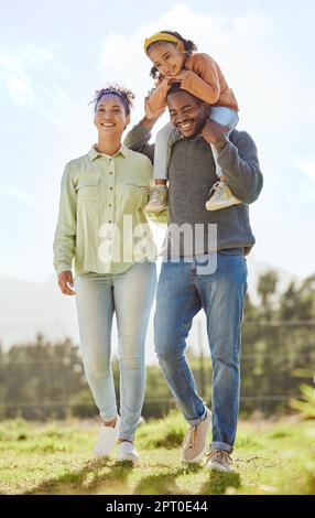 Famille noire, papa porte fille et extérieur pour des moments de qualité, heureux et sourire ensemble à l'extérieur. Parents, maman et papa avec fille marchant, liant et b Banque D'Images