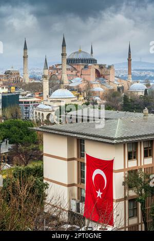 Drapeau turc sur un bâtiment avec la grande mosquée Sainte-Sophie (Ayasofya) en arrière-plan, Istanbul, Turquie Banque D'Images