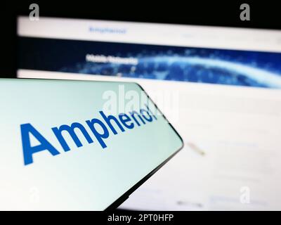 Téléphone portable avec logo de la société américaine d'électronique Amphenol Corporation à l'écran devant le site Web. Concentrez-vous sur le centre de l'écran du téléphone. Banque D'Images