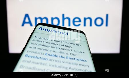 Téléphone mobile avec page Web de la société américaine d'électronique Amphenol Corporation à l'écran devant le logo d'entreprise. Faites la mise au point dans le coin supérieur gauche de l'écran du téléphone. Banque D'Images