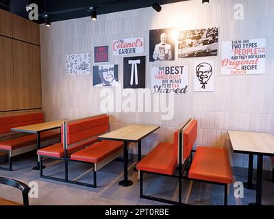 DUSHANBE, TADJIKISTAN - 28 AOÛT 2022 : le mur du restaurant de restauration rapide KFC avec le colonel Sanders vieilles photos et photos, tables et chaises à l'intérieur. Banque D'Images