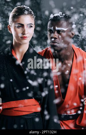 Mystique culturelle. Photo de mode d'un homme et d'une femme portant des vêtements de style oriental dans la neige qui tombe Banque D'Images