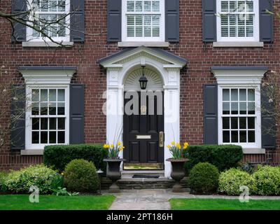 Porte d'entrée de la maison traditionnelle en brique de deux étages avec des volets Banque D'Images