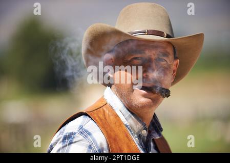 HES le wrangler des bêtes. Un cowboy mature à l'extérieur sur sa ferme Banque D'Images