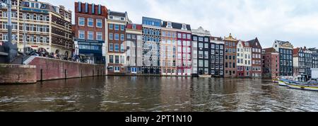 AMSTERDAM, HOLLANDE - 18 AVRIL 2023 : des maisons hollandaises typiques bordent un canal dans la capitale des pays-Bas, connue pour son patrimoine artistique, son système de canaux élaboré Banque D'Images