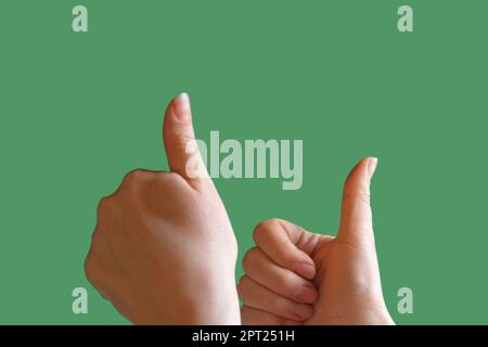 Gestes. Main femelle avec manucure beige montrant le pouce vers le haut et le pouce vers le bas isolée sur fond d'écran vert Chroma Key. Langage corporel. Gros plan. Li Banque D'Images