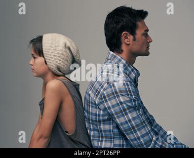 Sa hanche pour être la hanche. Photo studio d'un père et d'un fils branchés dos à dos sur fond gris Banque D'Images