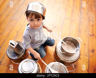 Toutes les demandes du public. un adorable petit garçon drumming sur des casseroles et des poêles Banque D'Images