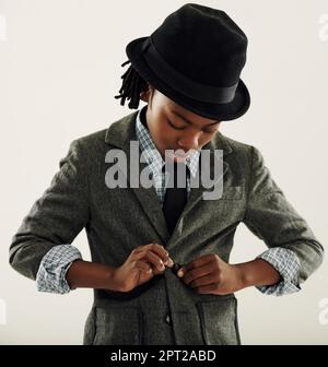 Vous n'êtes jamais trop jeune pour avoir un look élégant. Un jeune garçon afro-américain habillé dans une veste avec une cravate et un chapeau Banque D'Images