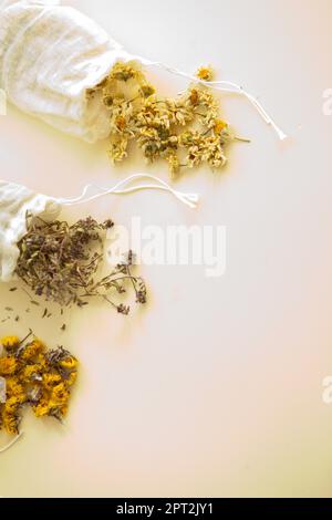 herbes séchées dans des sacs blancs de coton par le dessus. Sachets remplis de chamomilla médicinales et de petits pains Banque D'Images
