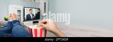 Manger Popcorn regarder la télévision sur canapé. Séjour Banque D'Images