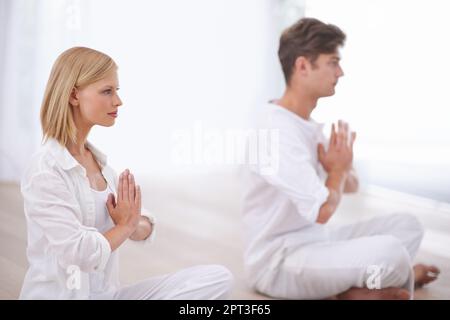 Trouver la paix intérieure ensemble. Deux personnes assises à pattes croisées et faisant du yoga ensemble Banque D'Images