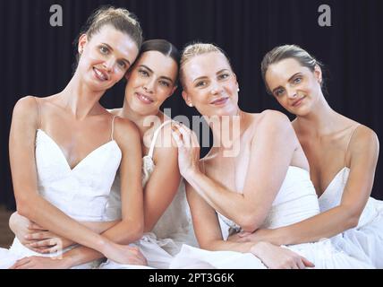 Portrait d'un groupe de ballerines dans le studio, assis sur le sol. De jeunes danseurs de ballet se posent et sourient ensemble dans un studio de danse ou sur un cerf Banque D'Images