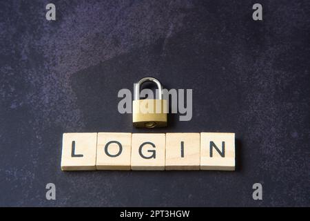 Mot 'login' écrit en lettres de bois à côté d'un cadenas représentant le concept de sécurité réseau. Cyber ​​security, protection contre la fraude. Banque D'Images