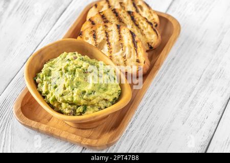 Bol de guacamole sur fond blanc Banque D'Images