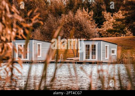 Couple de cabines flottantes grises sur le lac. Vivre sur une maison flottante est très attrayant. Banque D'Images