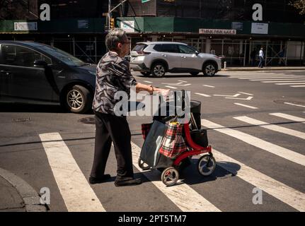 Une femme âgée, dans un climat chaud et peu saisonnier, traverse la rue de Greenwich Village à New York jeudi, 13 avril 2023. Les températures printanières devraient atteindre près de 90 degrés, ce qui fait que le mois d'avril ressemble davantage à celui de juillet. (© Richard B. Levine) Banque D'Images