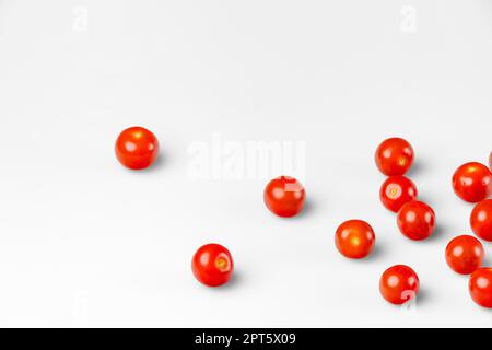 Tomates cocktail rouges sur fond blanc, espace de copie Banque D'Images