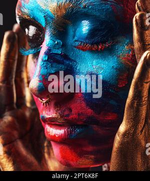 Il y a de la beauté dans l'art chaotique une jeune femme attrayante posant seule dans le studio avec de la peinture sur son visage Banque D'Images