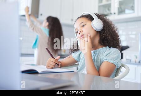 Parlez librement, vous pourriez changer le monde. une petite fille regardant bien réfléchie faisant ses devoirs à la table de cuisine Banque D'Images