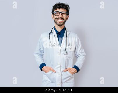 Médecin souriant sur fond isolé. Médecin heureux avec les mains dans les poches. Portrait du jeune médecin souriant isolé Banque D'Images