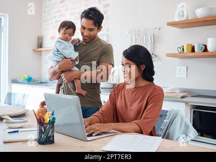 Internet, famille et parents faisant des recherches sur le syndrome de Down avec bébé sur un ordinateur portable dans leur maison. Mère et père avec le sourire pour l'enfant et le travail Banque D'Images