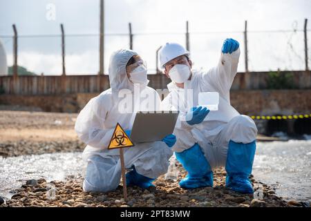 L'échantillonnage écologiste a amené les poissons morts en inspaction et enregistrer les données sur ordinateur portable, le biologiste porter une combinaison de protection et un masque recueille l'échantillon de déchets wa Banque D'Images