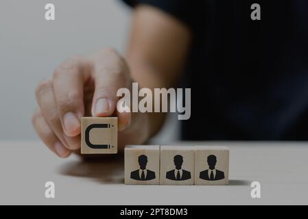 Mettez à la main des cubes en bois avec des icônes et des symboles de marketing entrant sur la table et l'espace de copie.concepts d'affaires. Banque D'Images