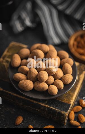 Amandes en chocolat enrobées de cacao sur une assiette. Banque D'Images