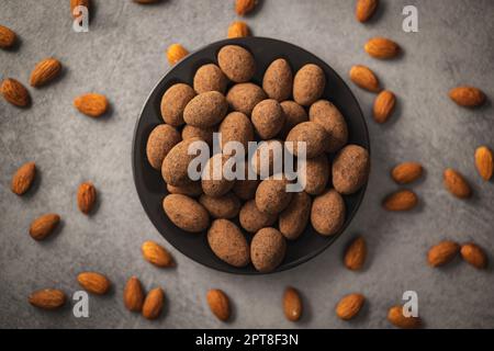 Amandes en chocolat enrobées de cacao sur une assiette. Vue de dessus. Banque D'Images