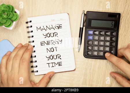 Affaires et finances. Sur la table se trouvent deux feuilles d'un bloc-notes et un stylo sur fond jaune écrit - GÉREZ VOTRE ÉNERGIE ET NON VOTRE TEMPS Banque D'Images