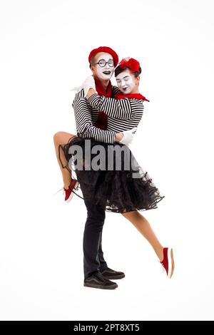 Smiling mimes en chemises à rayures. Homme et femme dansant isolé sur fond blanc Banque D'Images