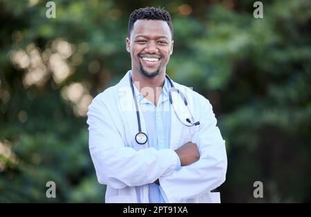 Im votre médecin de quartier amical. un jeune homme médecin debout avec ses bras croisés dans la nature Banque D'Images